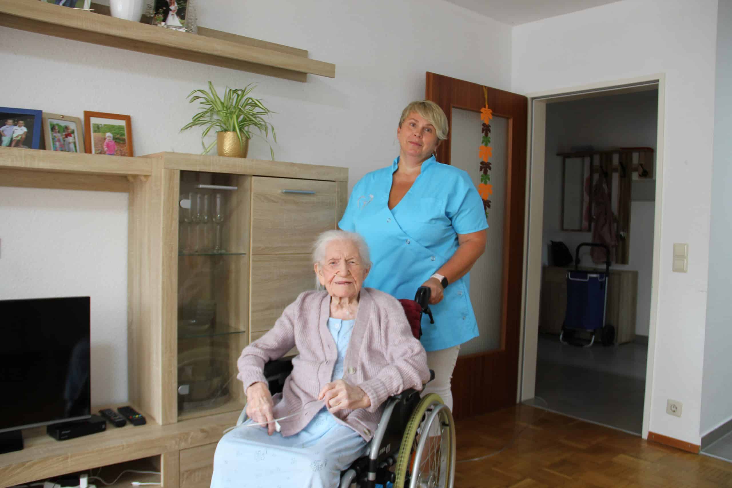 Pflegekraft unterstützt Seniorin im Rollstuhl bei der Grundpflege zu Hause in Heilbronn