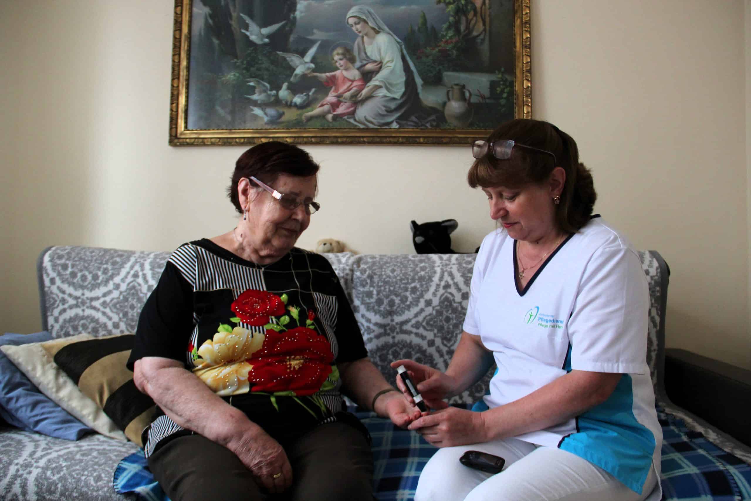 Pflegekraft im Gespräch mit einer Seniorin